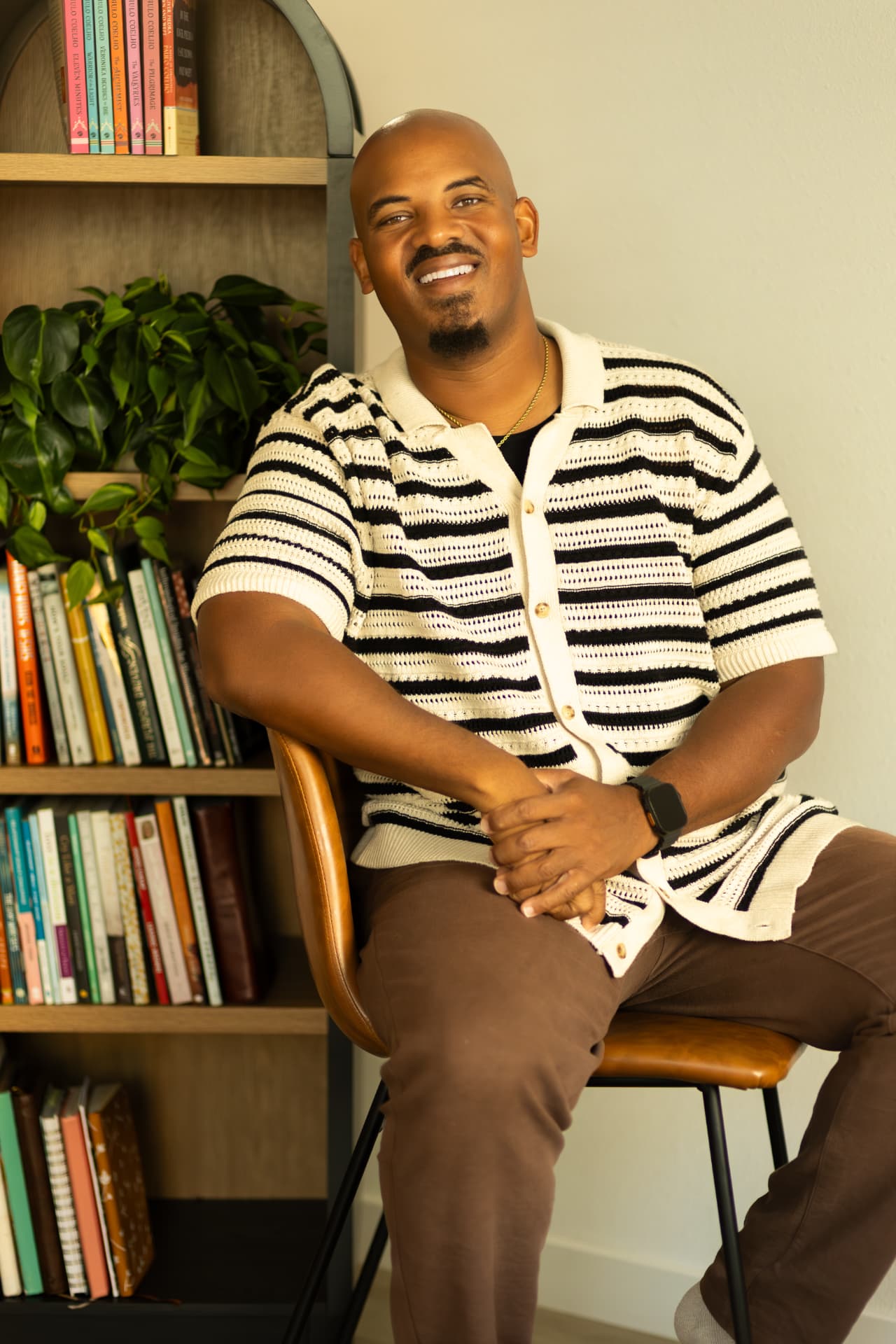 Brandon Jackson seated by a bookshelf, founder of Sinapi